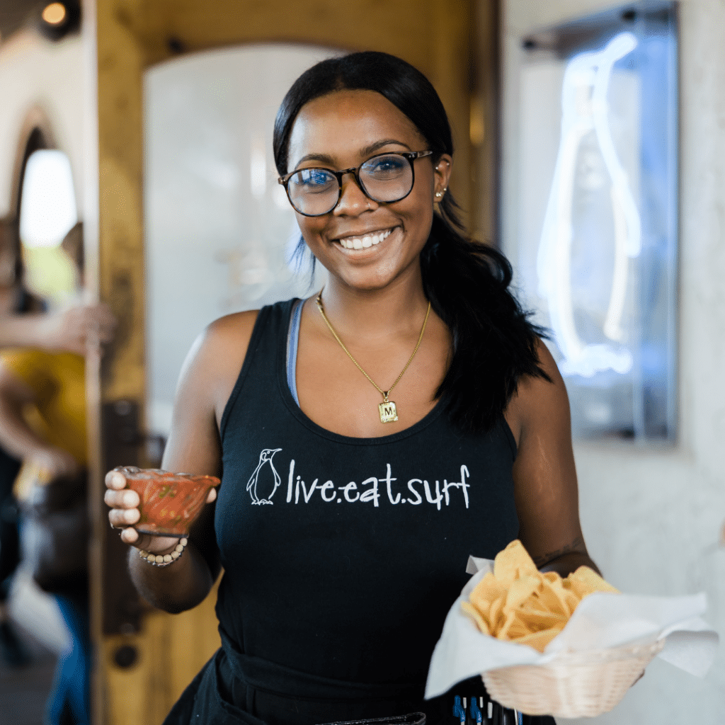 A Tower7 waitress serving chips and salsa.
