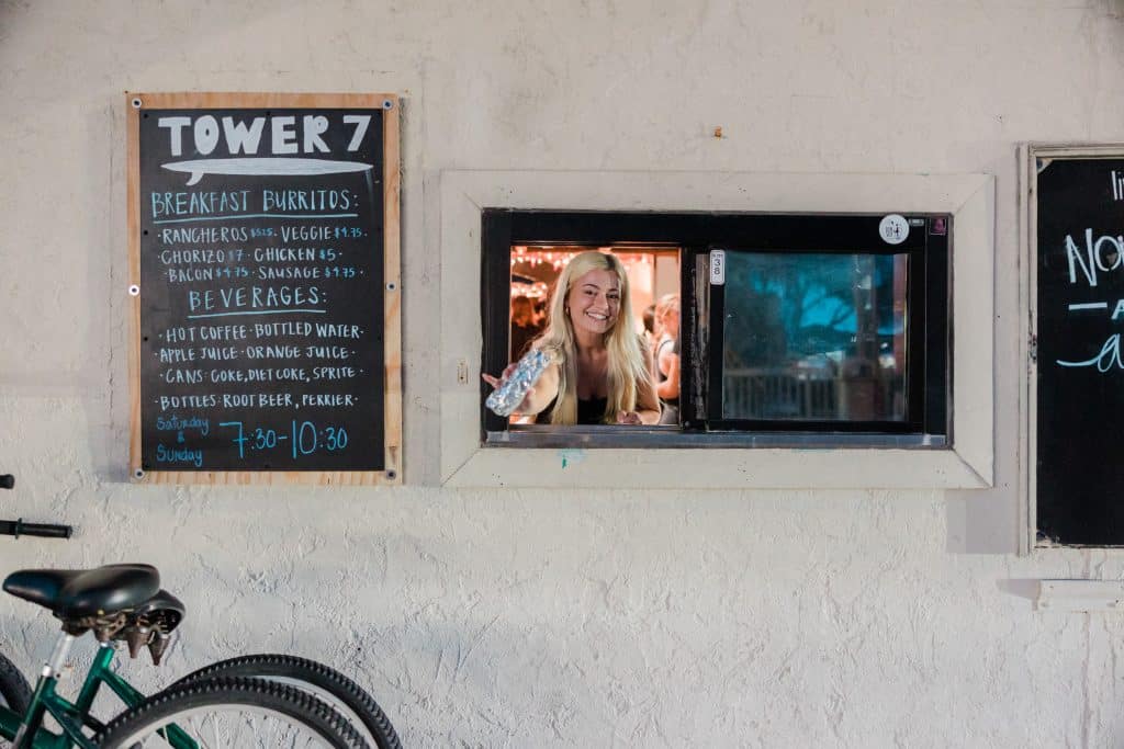 A Tower7 employee passing a wrap through a drive-through window.