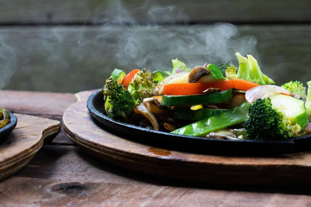 A steamy fajita with chopped vegetables and mushrooms.